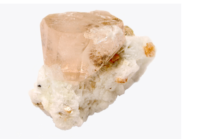 Kristalliner Quarz in brauner Farbe auf hellem, mineralischem Gestein.